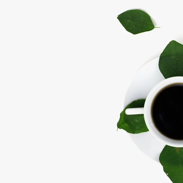 Płaski lay, Blat biurowy widok z góry. Obszar roboczy z zielonym liściem i filiżanką kawy na białym tle. Czarna mocna kawa w białej filiżance. Widok z góry, miejsce na tekst — Zdjęcie stockowe