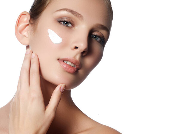 Молодая брюнетка снимает макияж с лица. Фото красивой девушки с ватными прокладками на белом фоне. Уход за кожей и концепция красоты. Копирование пространства
