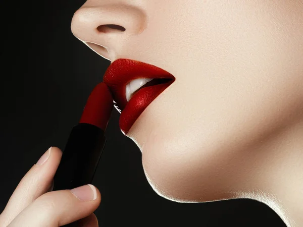 Cosmetica, make-up en trends. Heldere lipgloss en lippenstift op de lippen. Close-up van mooie vrouwelijke mond met rode lip make-up. Prachtige deel van het vrouwelijke gezicht. Perfect schone huid — Stockfoto