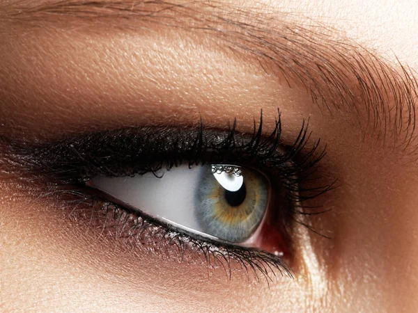 Zbliżenie woman niebieski oko z piękny brązowy makijaż smokey oczy odcieniach. Nowoczesnej mody makijaż. Nagie makijaż. Czystą skórę, długie rzęsy — Zdjęcie stockowe