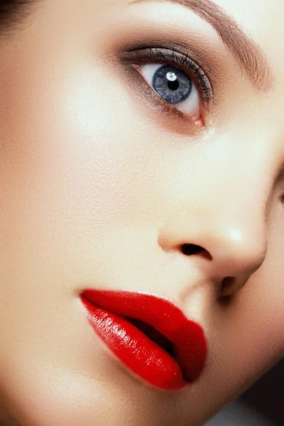 Piękna Brunetka kobieta z idealny makijaż. Piękne wakacje profesjonalny makijaż. Czerwone usta, brwi idealne. Piękna dziewczyna twarz. Złoty wisiorek i kolczyki z pereł i diamentów — Zdjęcie stockowe
