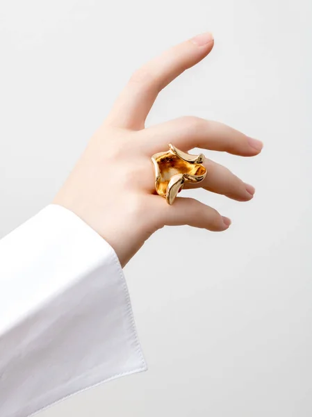 Simple beauty concept - jewelry accessories . Beauty delicate hands with manicure close up . Beautiful female fingers with manicure and fashionable gold ring . Minimalistic fashion photography