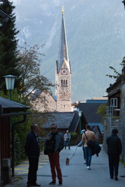 people walking at street of mountain village in Hallstatter See, Austria clipart