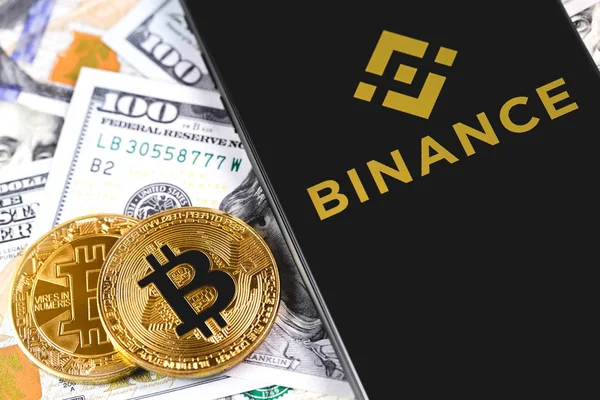 Биткоины, доллары с логотипом Binance на экране смартфона . — стоковое фото