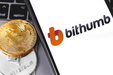 İki bitcoin, ekranda kripto borsasının Bithumb logosu 