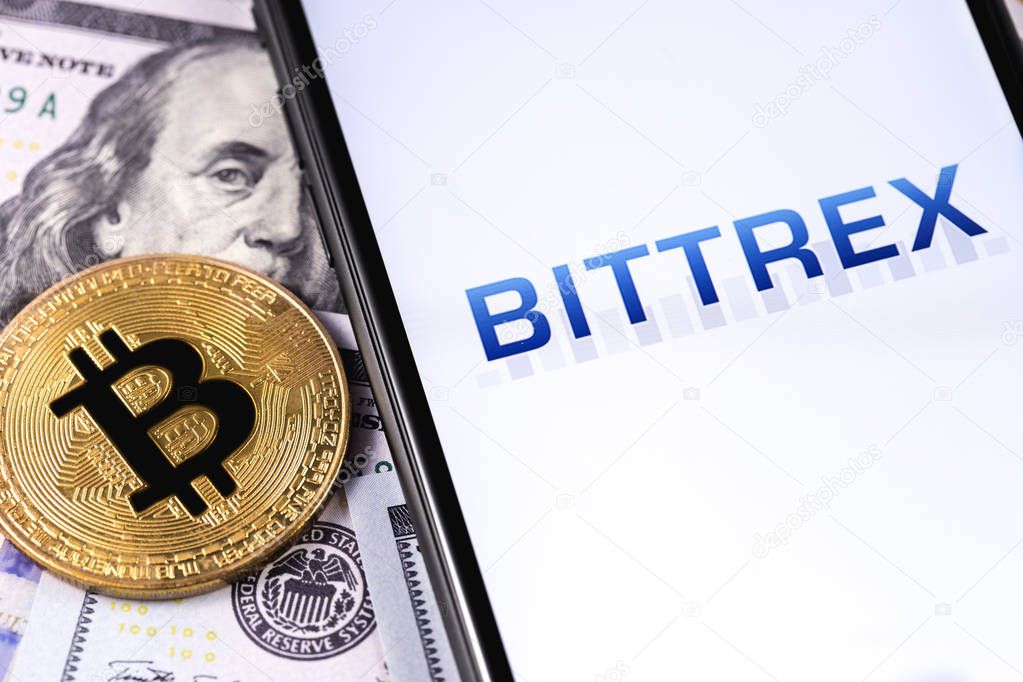 Bittrex cryptocurrency exchange website displayed on smartphone and stack of money, dollars, bitcoin. Moscow, Russia - March 1, 2019