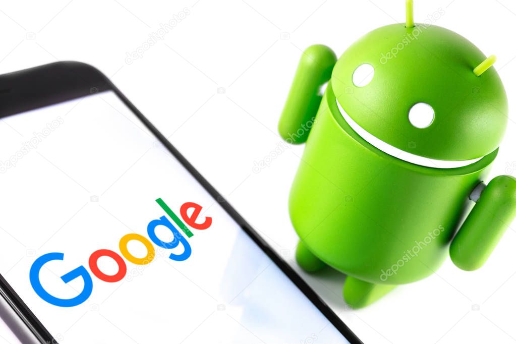 Closeup Google Android figure and smartphone with Google logo. Google Android is the operating system for smartphones, tablet computers and other devices. Moscow, Russia - March 17, 2019