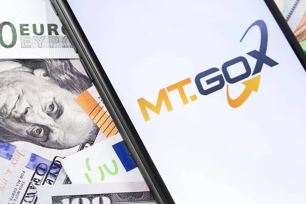 钱和Mt.Gox标志交换在屏幕上的智能手机。山 — 图库照片