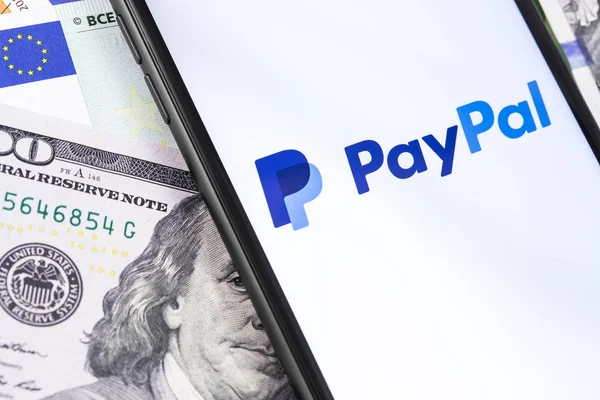 Pénz és a PayPal logó a képernyőn okostelefon. PayPal egy int — Stock Fotó
