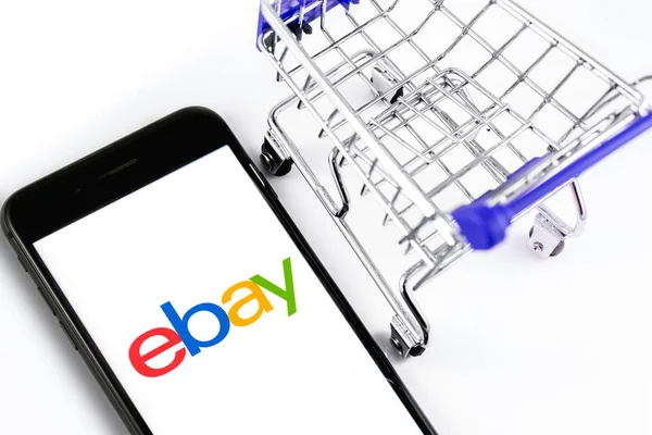 Carrello della spesa e logo eBay sullo schermo smartphone. eBay è sopra — Foto Stock
