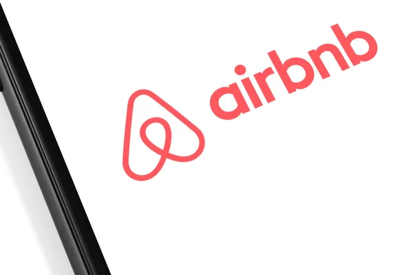 Smartphone com logotipo Airbnb na tela. Airbnb é um m online — Fotografia de Stock