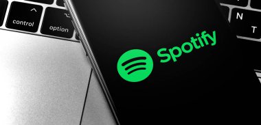 ekranda Spotify logolu yakın çekim Macbook ve iphone