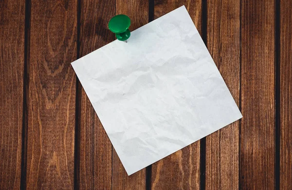 Een witte lege zelfklevende papier op houten bureau achtergrond — Stockfoto