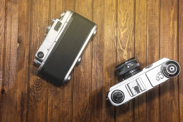 two retro cameras on wooden boards background