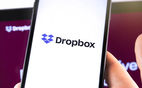 Notebook de close-up e smartphone com logotipo do Dropbox na tela . — Fotografia de Stock