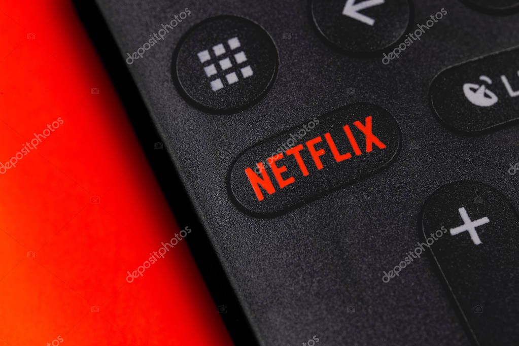 Netflix button on the remote controller on red background. Netflix is an international leading subscription service for watching TV episodes and movies. Moscow, Russia - April 19, 2019