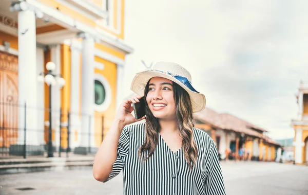 Tourist girl calling phone in the street. Happy travel woman calling on the phone in a tourist plaza