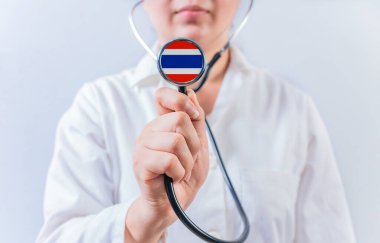 Tayland bayrağıyla steteskop tutan kadın doktor. Tayland 'ın Ulusal Sağlık Sistemi