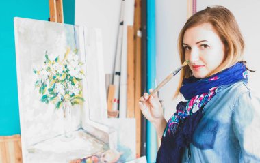 bir kız ressam portre renkli bir sanat stüdyosu resimlerinde bir palet ile. Düşünceli sanatçı, yaratıcı ruh hali