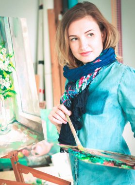 bir kız ressam portre renkli bir sanat stüdyosu resimlerinde bir palet ile. Düşünceli sanatçı, yaratıcı ruh hali