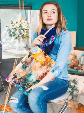 bir kız ressam portre renkli bir sanat stüdyosu resimlerinde bir palet ile. Düşünceli sanatçı, yaratıcı ruh hali