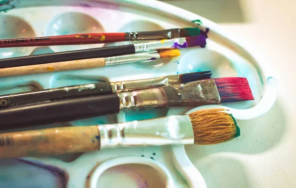 yaratıcı görüntü, sanatçının paletle yağlı boya ve fırça, yakın çekim