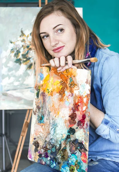bir kız ressam portre renkli bir sanat stüdyosu resimlerinde bir palet ile. Düşünceli sanatçı, yaratıcı ruh hali