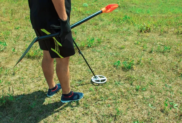 Man in a field with a metal detector in his hand. search for coins and treasures by a metal detector, selective focus