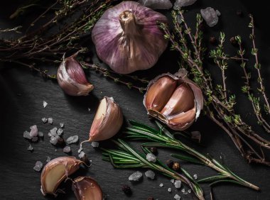 Sarım -sak. Siyah bir arka plan üzerinde sarımsak. Fındık, peynir, biberiye ve