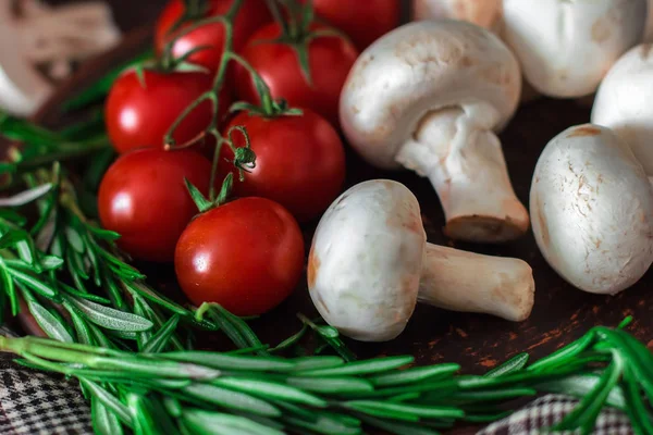 Fresh cherry tomatoes, sprigs of rosemary and champignon mushroo — Stock Image Fresh cherry tomatoes, sprigs of rosemary and champignon mushroo Royalty Free Stock Photos