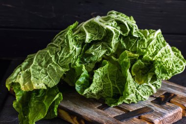 Koyu ahşap bir arka plan üzerinde bir kesim taze Çin lahanası. Diyet