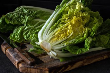 Koyu ahşap bir arka plan üzerinde bir kesim taze Çin lahanası. Diyet