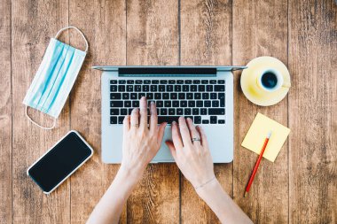 COVID salgını sırasında ofis bilgisayarında çalışıyor. Coronavirus sırasında şirket ya da ofis bilgisayarını kullanan genç bir kadın..