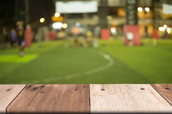 Empty wooden table of brown on front blurred grass background, copy space, for presentation