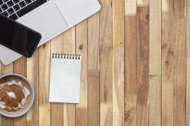 Dizüstü bilgisayar ve Not defteri ve Brown, uesd iş şablonu için kopya alanı ahşap masa üzerinde sıcak kahve 