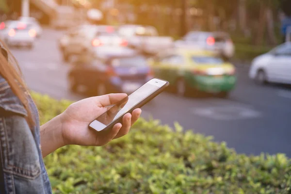 Vrouw houdt mobiele telefoon naast de weg, teachnology people concept — Stockfoto