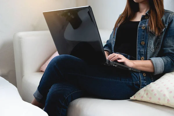 Close-up van Aziatische vrouw zittend op de Bank tijdens het gebruik van laptop Compu — Stockfoto