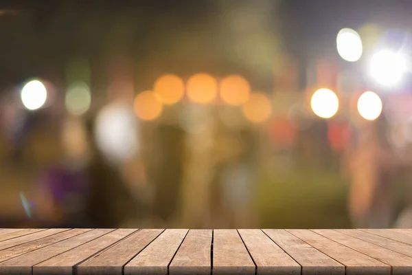 Wazig houten tafel in de voorkant wazig nacht straatmarkt met b — Stockfoto