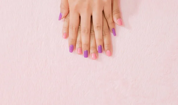 ピンクの背景に女性の手の爪の色を閉じます — ストック写真