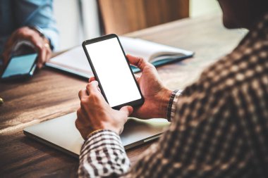 Kafede genç adamın elinde boş ekran mobil