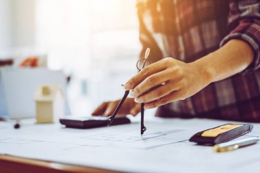 Ofis işyerinde kadın mimar çizim planları.