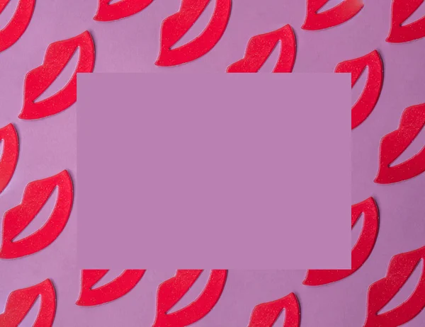 Red female lips pattern on pink background with copy space