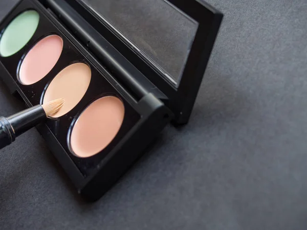 Siyah arka plan üzerine farklı makyaj düzelticiler paletle