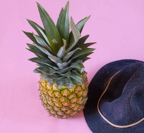 Pineapple and blue hat  on pink background