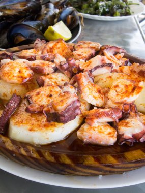 Ahtapot ve patates ahşap plaka üzerinde kırmızı biber ve zeytin yağı ile pişirilir. Galiçyaca gıda