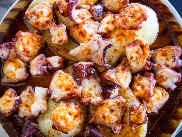 Ahtapot ve patates ahşap plaka üzerinde kırmızı biber ve zeytin yağı ile pişirilir. Galiçyaca gıda