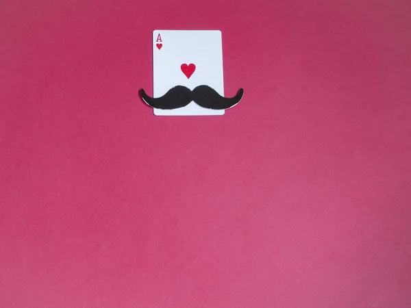 Mustache and ace hearts card on red background