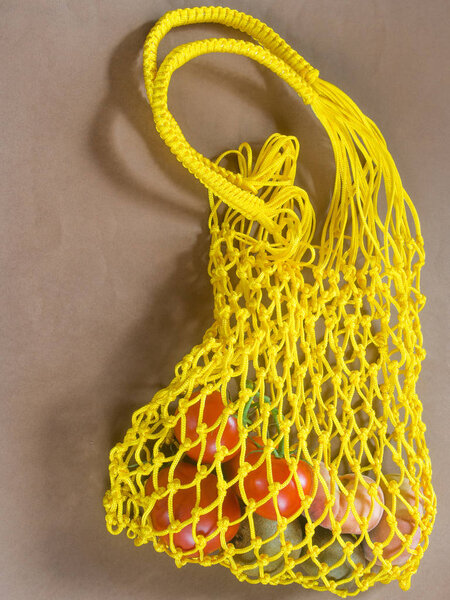 Yellow bag with vegetable on brown background