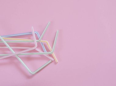 Kopyalama alanı ile pembe arka plan üzerinde plastik pipetler