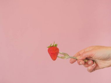 Kopya s ile pembe arka plan üzerinde çilek ve eski çatal ile El